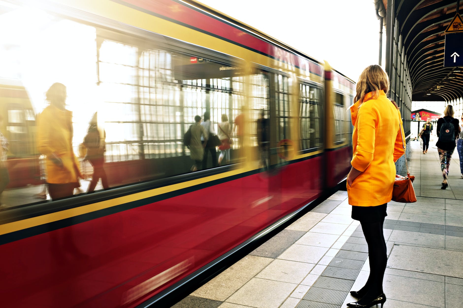 woman standing beside red train